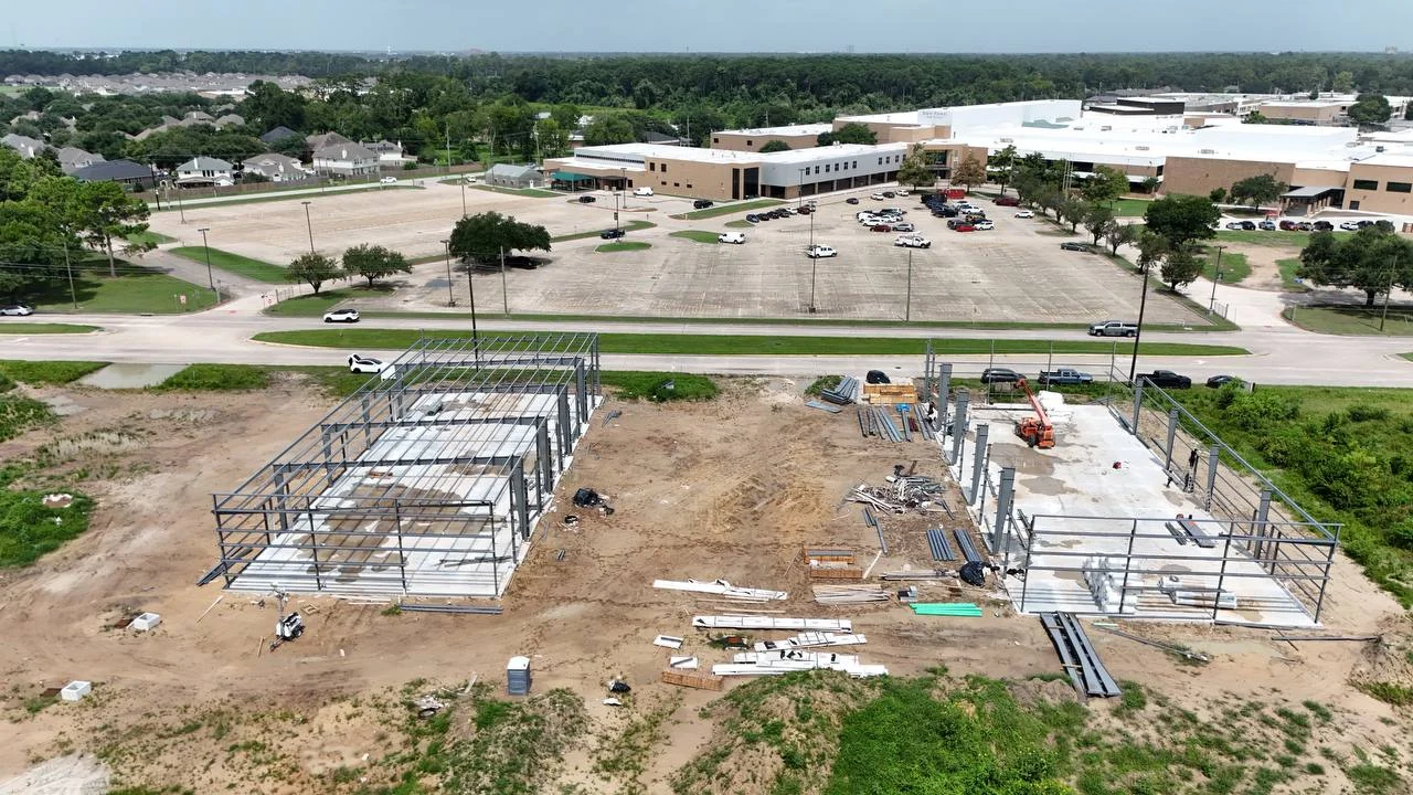Bammel Business Park Phase 1 aerial, 16 July 2026 (Day 137): PEMB structural steel frames erected on both cast slabs — both buildings framed with columns and rafters up, girts and sheeting to follow, 12902 Bammel N Houston Rd, Houston TX 77066