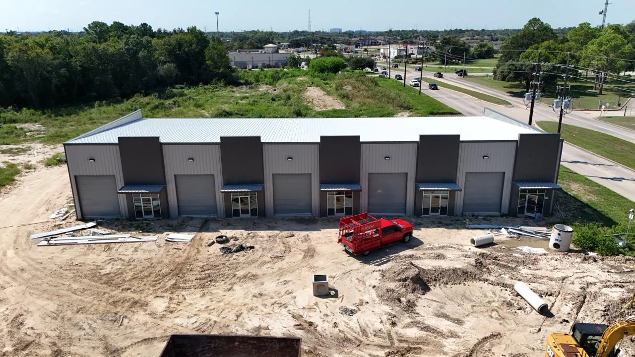 Bammel Business Park Phase 1 aerial drone photo, 22 September 2026 (Day 205): front flex warehouse building with roll-up doors hung and glass storefront entries under metal canopies, site work and utilities underway, 12902 Bammel N Houston Rd, Houston TX 77066