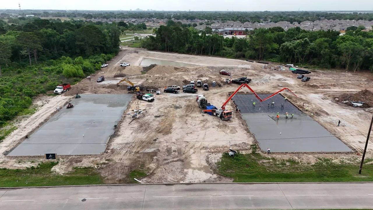 Bammel day 80: aerial view, both Phase 1 pads cast with concrete pump truck mid-second-pour, 18 May 2026